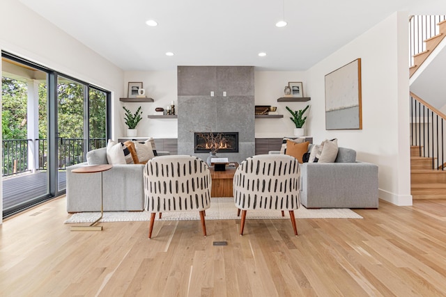 living room with light hardwood / wood-style floors and a tile fireplace