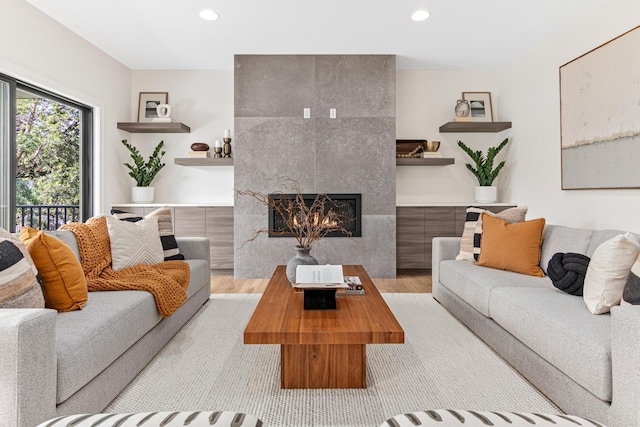 living room with light hardwood / wood-style flooring and a tile fireplace