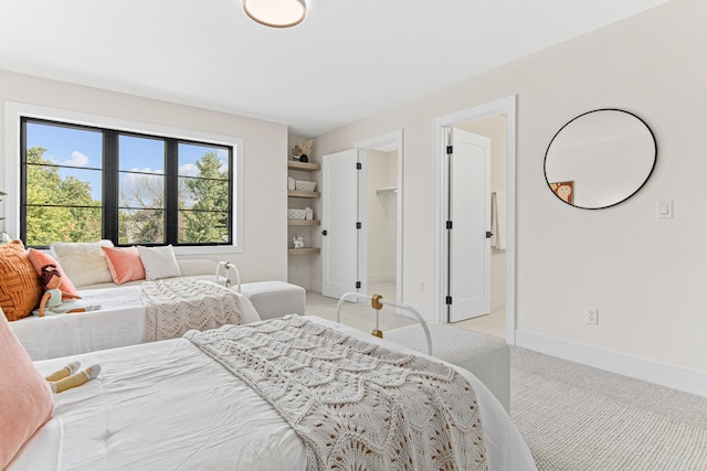 carpeted bedroom with a spacious closet and ensuite bath