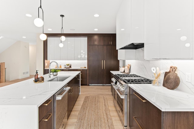 kitchen with appliances with stainless steel finishes, white cabinetry, pendant lighting, and sink