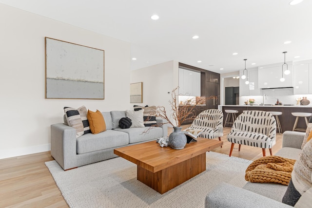 living room with sink and light hardwood / wood-style flooring