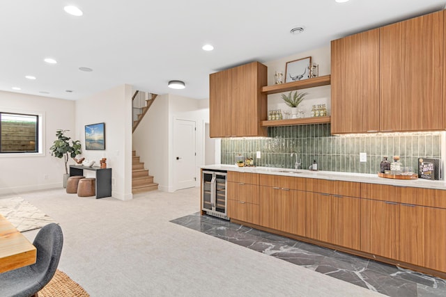 kitchen featuring sink, beverage cooler, backsplash, and dark colored carpet