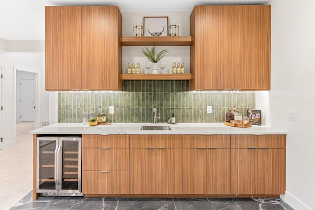 kitchen with sink, light stone countertops, tasteful backsplash, and wine cooler