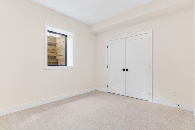 unfurnished bedroom with a closet and light carpet