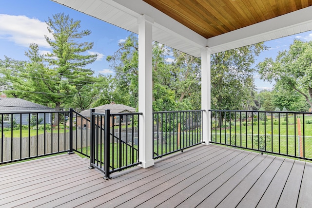 wooden deck featuring a lawn