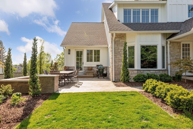 back of house with a lawn and a patio