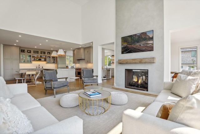 living room with light wood-type flooring and a high ceiling