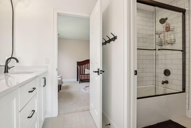 bathroom featuring combined bath / shower with glass door and vanity