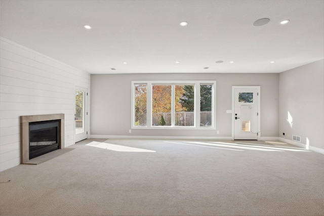 unfurnished living room featuring light carpet