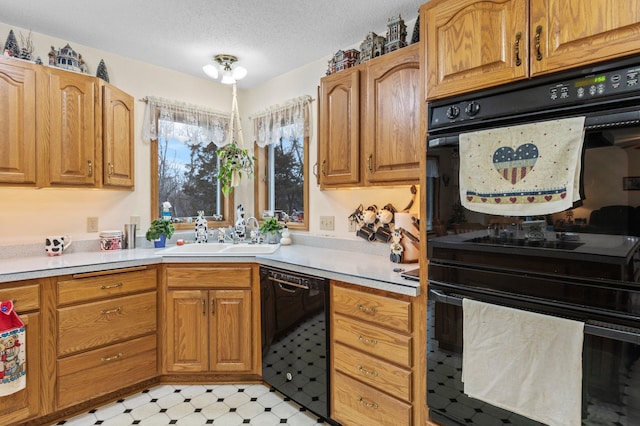 kitchen featuring sink, black appliances, and a textured ceiling