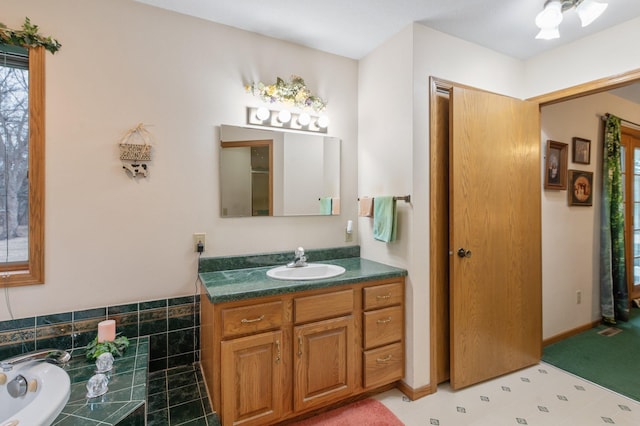 bathroom with vanity and tiled bath