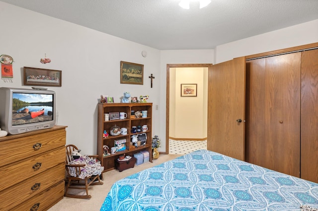 carpeted bedroom with a textured ceiling and a closet