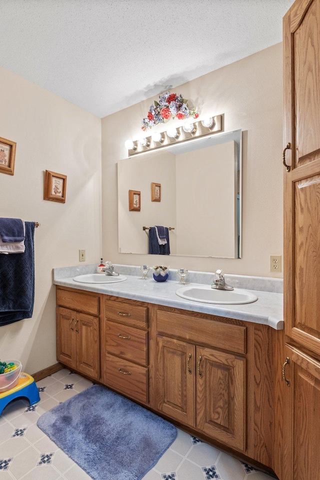 bathroom featuring tile patterned flooring, vanity, and a textured ceiling