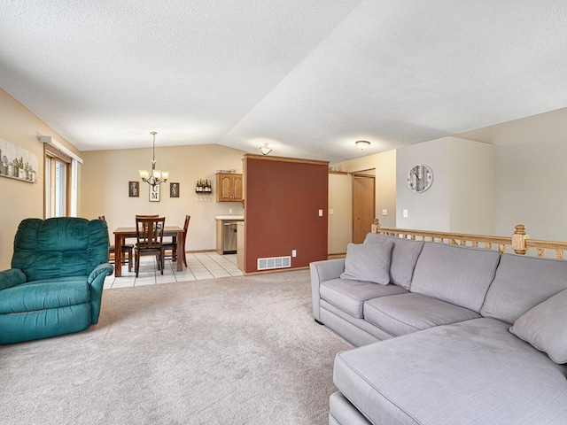 living room featuring an inviting chandelier, lofted ceiling, light carpet, and a textured ceiling