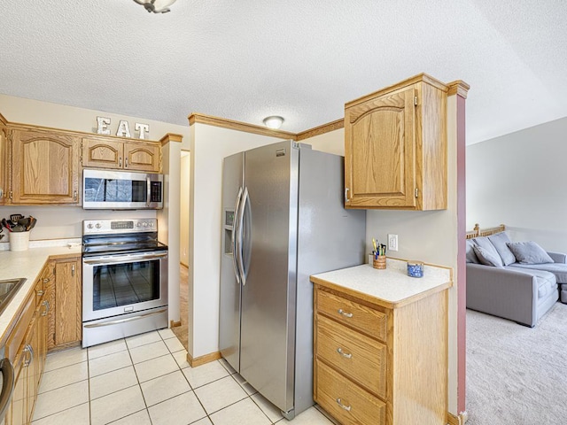 kitchen with light tile patterned flooring, a textured ceiling, and appliances with stainless steel finishes