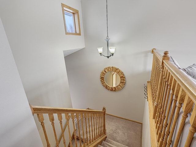 stairs with carpet flooring and a notable chandelier