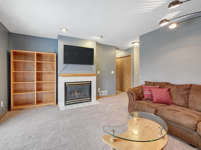 living room with light colored carpet, a textured ceiling, and a fireplace