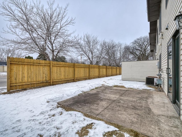 snowy yard featuring central AC