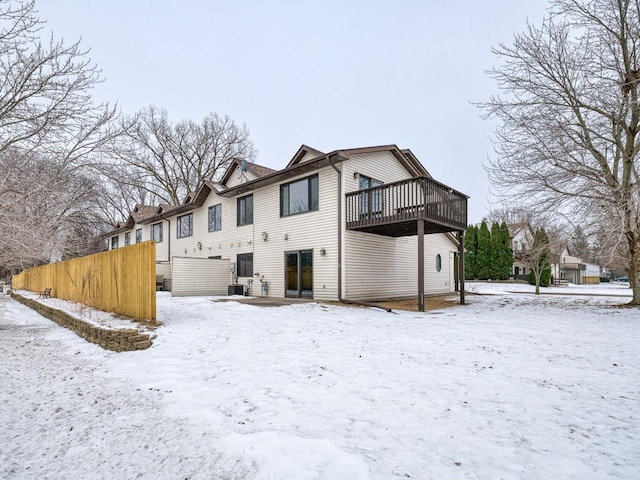 snow covered house with a wooden deck