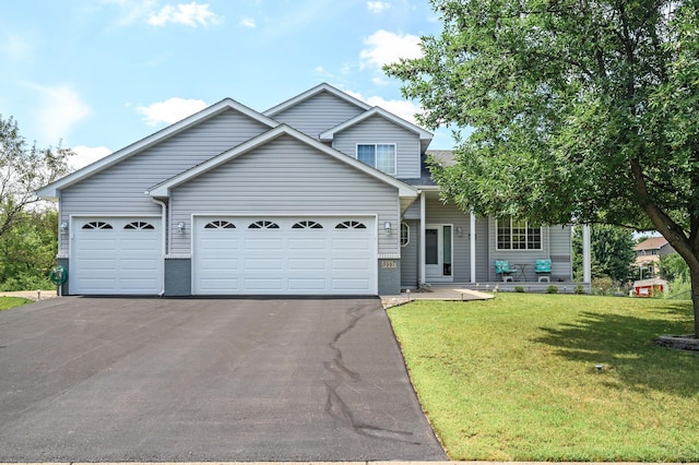 view of front of house with a garage, brick siding, a front lawn, and aphalt driveway