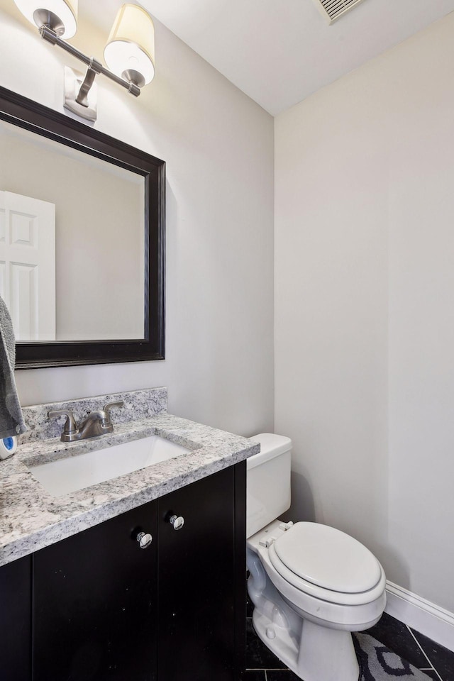 bathroom with tile patterned flooring, vanity, and toilet