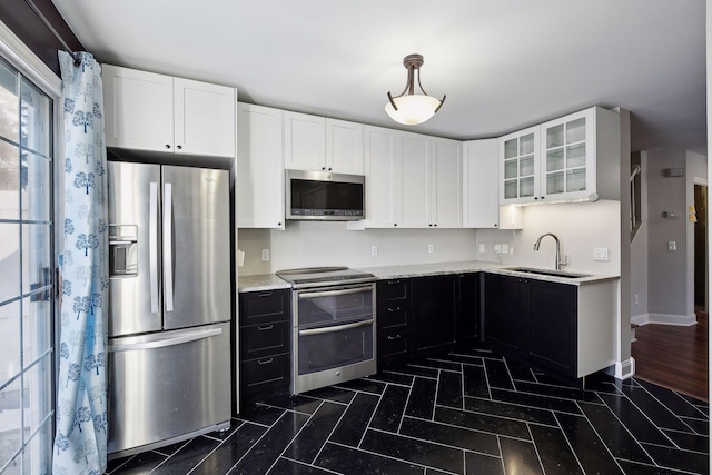 kitchen with sink, dark hardwood / wood-style flooring, stainless steel appliances, light stone countertops, and white cabinets