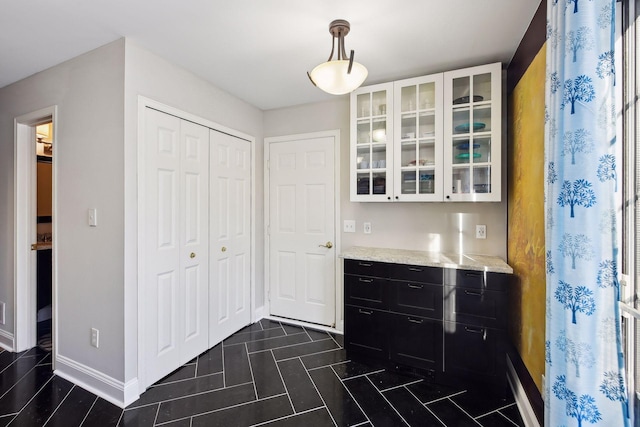 bar with white cabinetry, light stone countertops, and pendant lighting