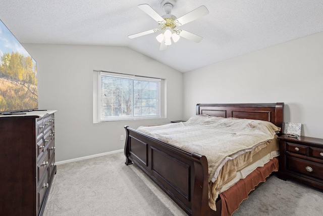 carpeted bedroom with ceiling fan, vaulted ceiling, and a textured ceiling