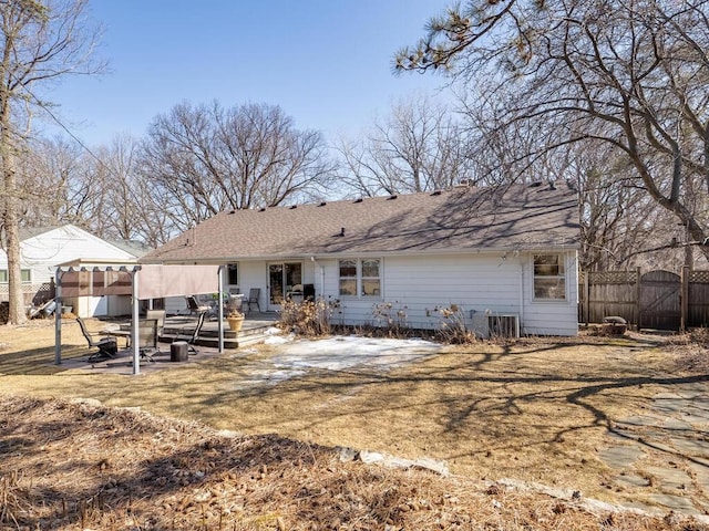 back of house with a gate, fence, roof with shingles, and a patio area