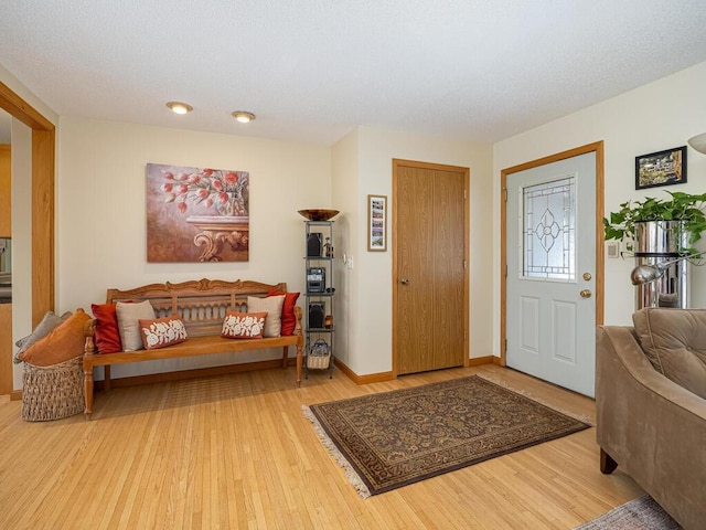 entryway featuring baseboards, a textured ceiling, and wood finished floors