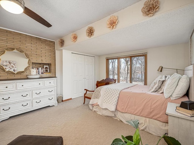 carpeted bedroom with a closet, a textured ceiling, and ceiling fan