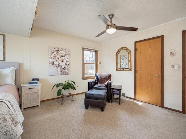 living area featuring baseboards, a textured ceiling, a ceiling fan, and carpet