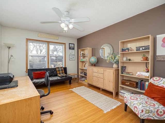 office space with light wood-type flooring, a textured ceiling, and a ceiling fan