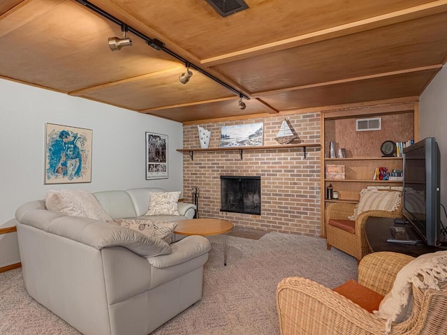 living area featuring track lighting, a brick fireplace, visible vents, and carpet floors