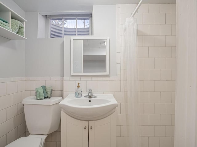 bathroom featuring tile walls, a shower with shower curtain, toilet, and vanity