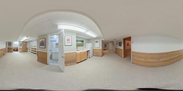 bonus room featuring a sink, light colored carpet, and vaulted ceiling