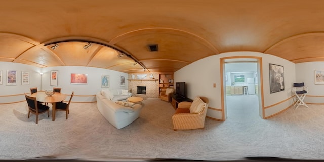 living room with baseboards, a brick fireplace, and vaulted ceiling