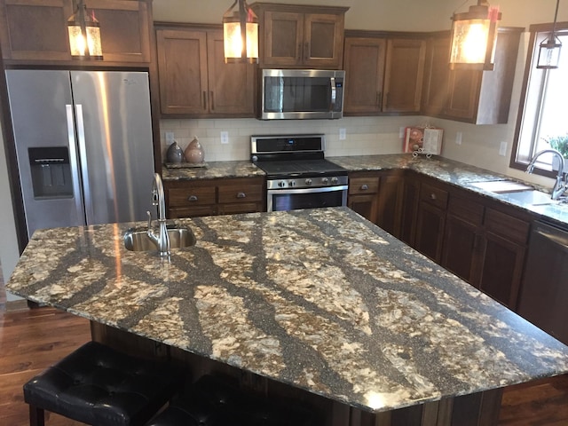 kitchen featuring sink, backsplash, a center island, and stainless steel appliances