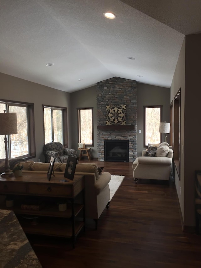 living room featuring vaulted ceiling, a textured ceiling, a fireplace, and dark hardwood / wood-style floors