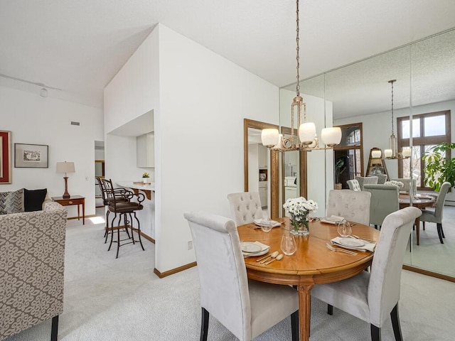 dining space featuring a notable chandelier, baseboards, and light colored carpet