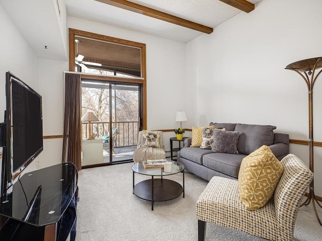 carpeted living area with beamed ceiling and baseboards