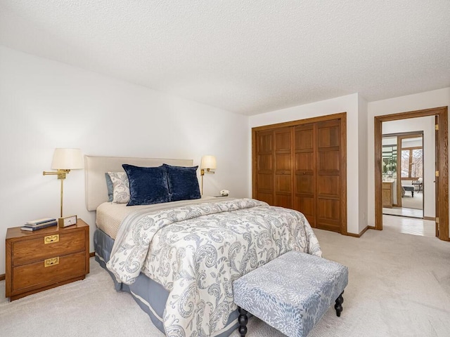 bedroom with a closet, baseboards, a textured ceiling, and carpet flooring