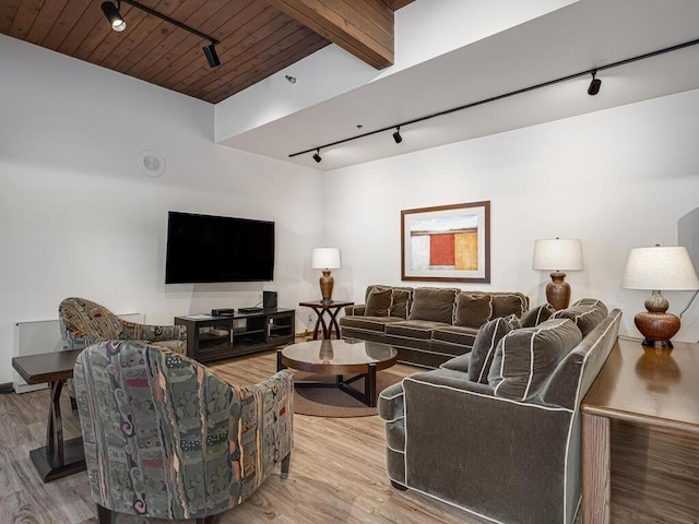 living area with beamed ceiling, track lighting, wood finished floors, and wooden ceiling