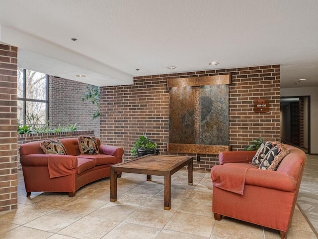 living area with brick wall and a textured ceiling