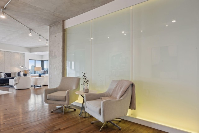 living area with track lighting and hardwood / wood-style flooring