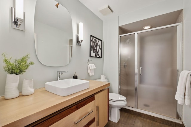 bathroom featuring toilet, an enclosed shower, and vanity