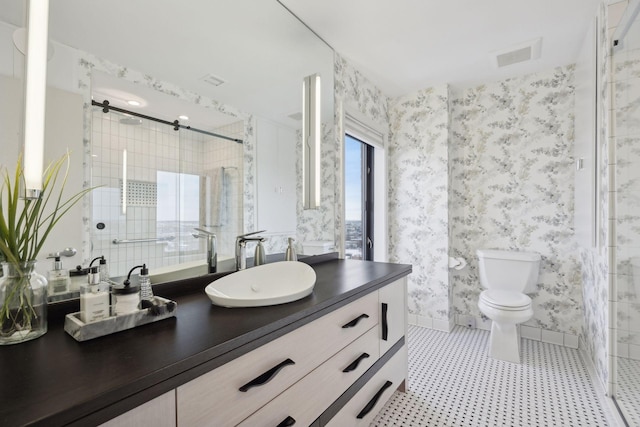 bathroom with toilet, vanity, and a shower with shower door