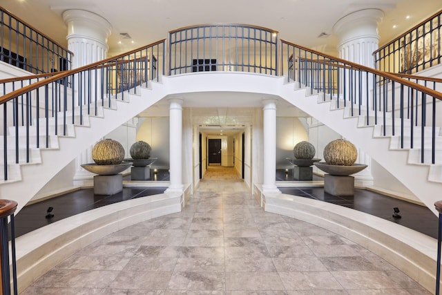 staircase with a towering ceiling and ornate columns