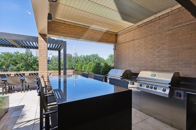 view of patio with exterior kitchen, exterior bar, a pergola, and a grill