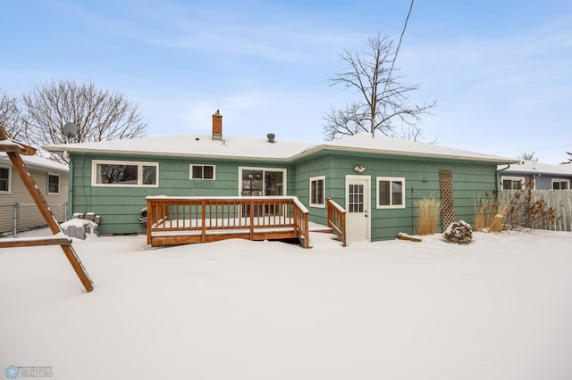 snow covered back of property featuring a deck